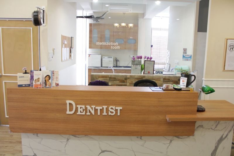 DENTAL-CLINIC-SETTING-WITH-A-COUNTER-THAT-HAS-A-SIGN-STATING-DENTIST-WITH-A-STERILISATION-ROOM-BEHIND-IT